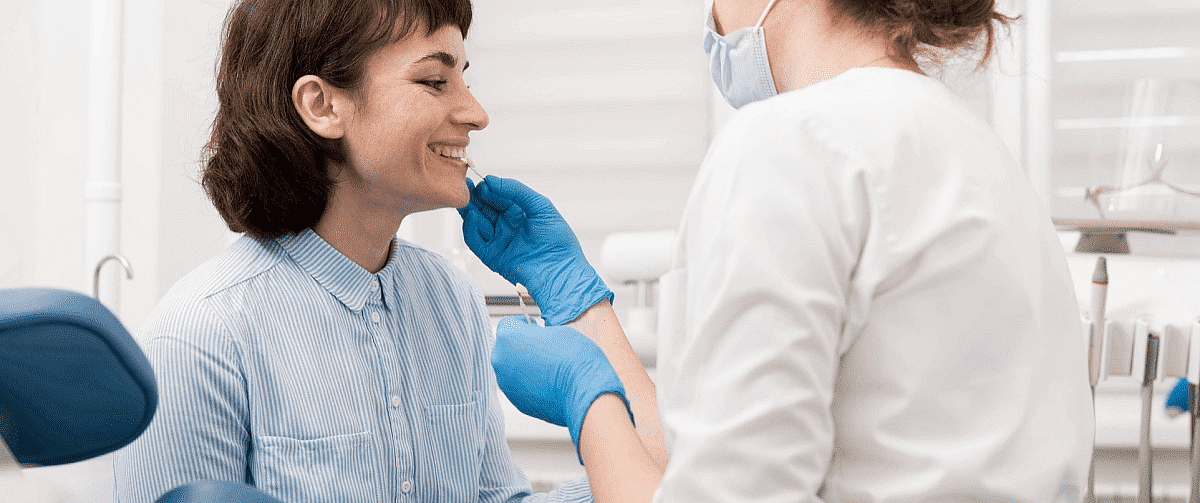 Orthodontist carefully examining a patient's teeth to monitor progress during orthodontic treatment in Liberty Township or Hamilton, OH