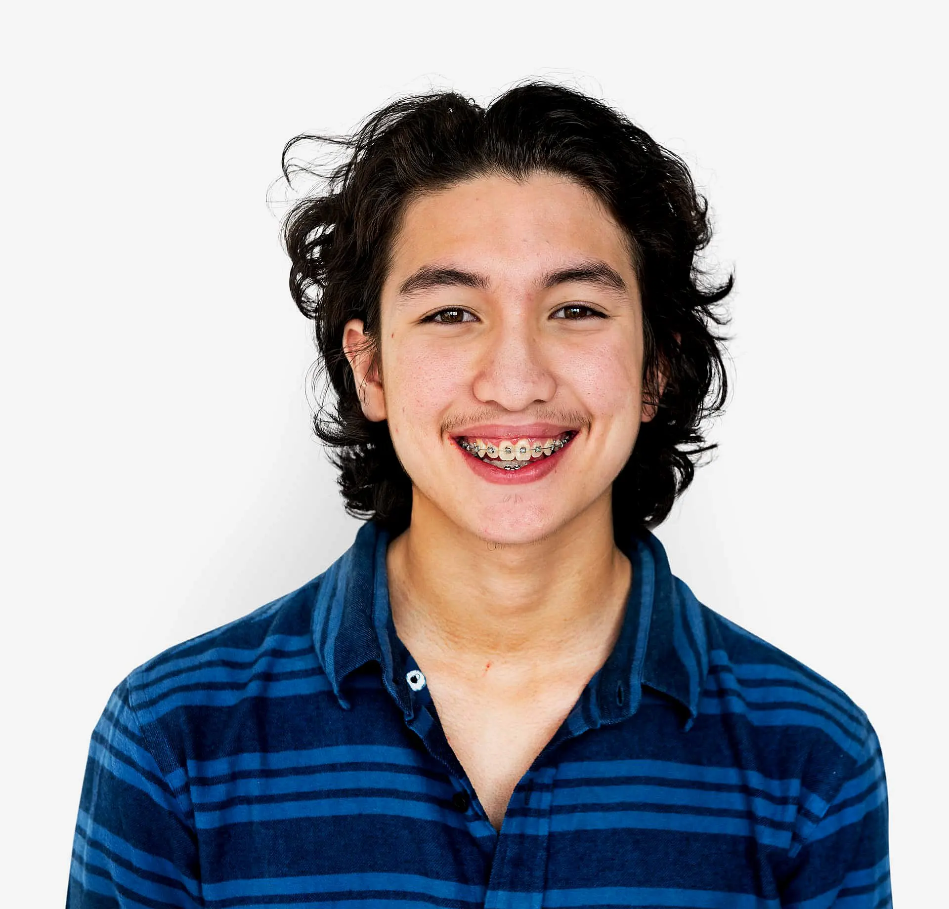 A person wearing a blue striped shirt smiles confidently, their braces gleaming against a white background in Liberty Township, OH