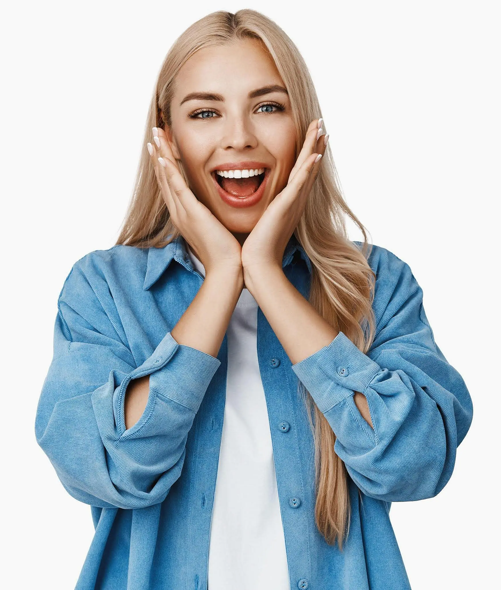 Woman with long blonde hair wearing a blue shirt and white top, smiling with hands on her face, standing against a white background at Queen City Orthodontics in Hamilton, OH.