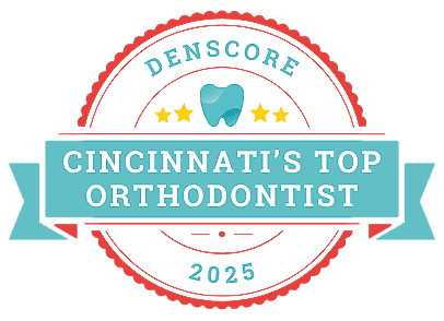 A badge with a tooth icon, three stars, and text reading "Denscore Cincinnati's Top Orthodontist 2025.